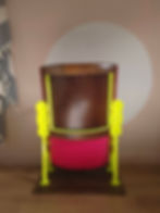 Thumbnail: View of the back of a bright pink and yellow cinema seat