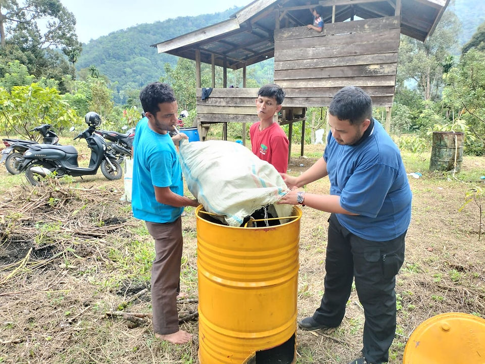 Producers enthusiastically observe the biochar production process, with the finished biochar and POC—reflecting their strong interest in sustainable agricultural innovations in TRANSFORM: Bestari project - Koltiva.com
