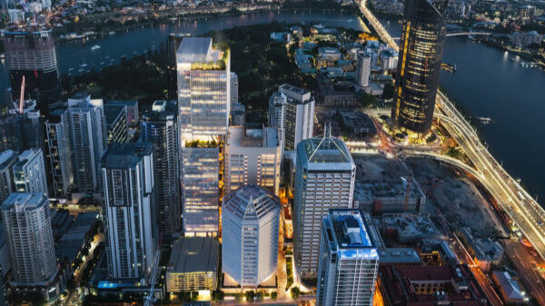 Aerial view of Brisbane CBD at dusk showing modern office towers and Brisbane River, representing QIC's Queensland headquarters location where their $83bn investment portfolio operations are managed with enhanced project transparency through Azure DevOps.