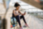 Female athlete using mobile phone sitting on steps