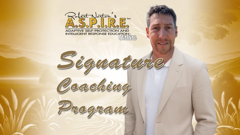 Robert J. Norton stands confidently in a light-coloured blazer beside the message: “Protecting ourselves shouldn’t be a conflict!” The image promotes A.S.P.I.R.E.™ Online, a trauma-aware coaching program helping people protect their peace and respond with calm, confidence, and clarity.