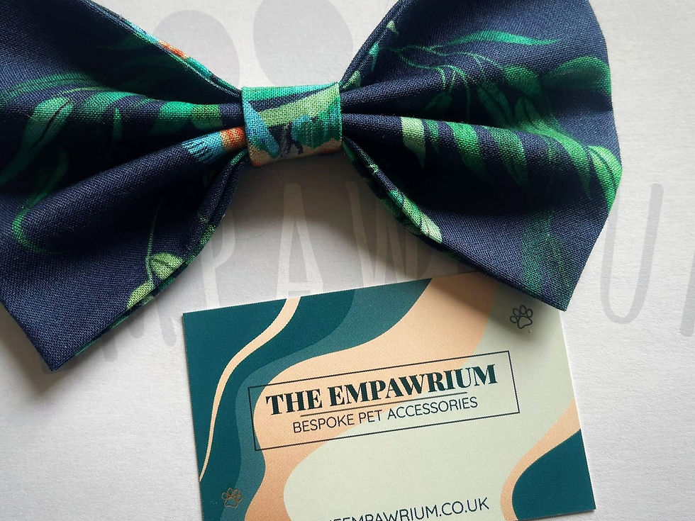 A close up of a pet collar bow tie in a leafy hummingbird print