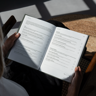 A person thoughtfully reviewing a brand audit checklist. The notebook is filled with questions designed to help businesses evaluate and improve their visual identity, brand voice, and overall brand strategy