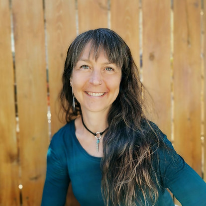 Dr. Julie Zepp posing in front of a fence