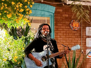 solo performer playing guitar in front of hostel