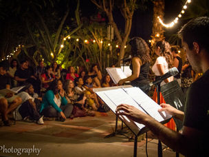 performers reading a play in front of crowd at hostel