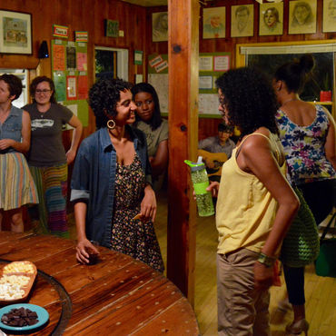 hostel common room with a group of people standing and talking