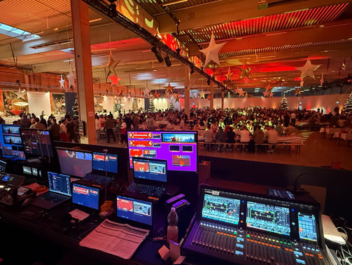 Eventregie mit Ton- und Lichttechnik bei einer großen Firmenweihnachtsfeier in der Werkshalle – volle Halle mit Gästen und festlicher Beleuchtung