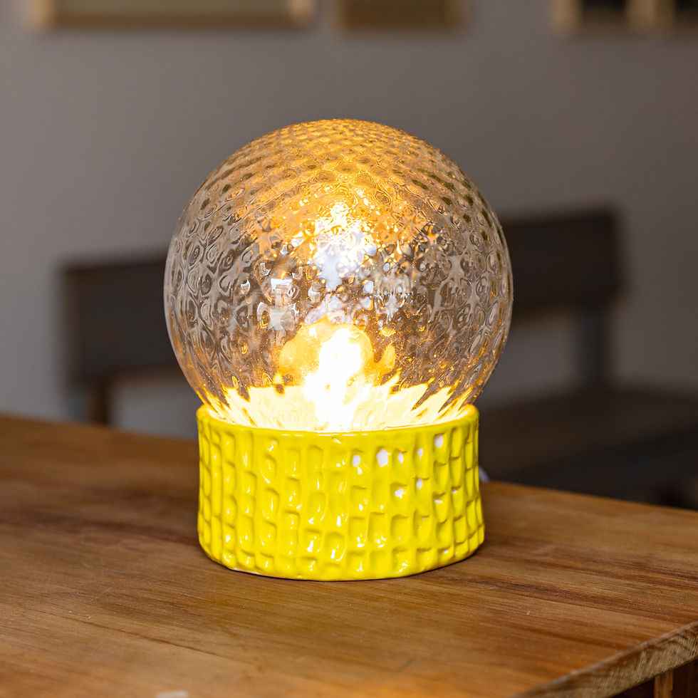 Diseño artesanal con base en cerámica amarilla y tulipa de vidrio esfera translucido.