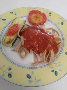 cooked pasta on plate with veggies and tomato sauce
