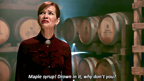 Gif of a woman with red hair in a room full of barrels looking distraught with the subtitle "Maple syrup! Drown in it, why don't you?"