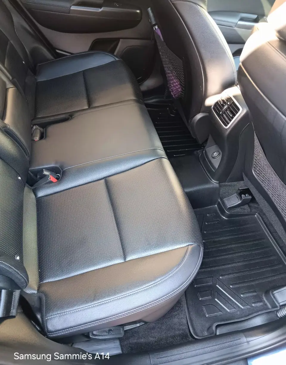 "Backseat of a vehicle with dark fabric upholstery, showing a detailed cleaning performed by Mack2Steam, highlighting the clean and refreshed condition of the seats."