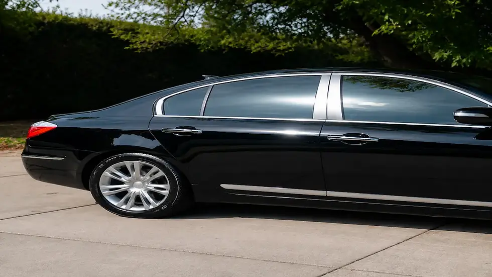 Black sedan with a high-gloss finish after professional ceramic coating, showcasing enhanced paint clarity and reflection.