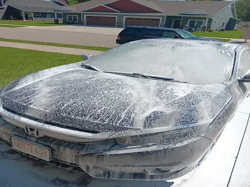 Vehicle covered in cleaning foam during a full car detail