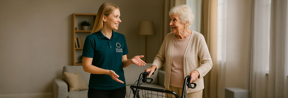 Elevate Mobility staff member smiling and speaking with an elderly woman using a rollator inside a living room, providing support and guidance.