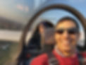 Pilot and passenger smile broadly while enjoying a glider flight.