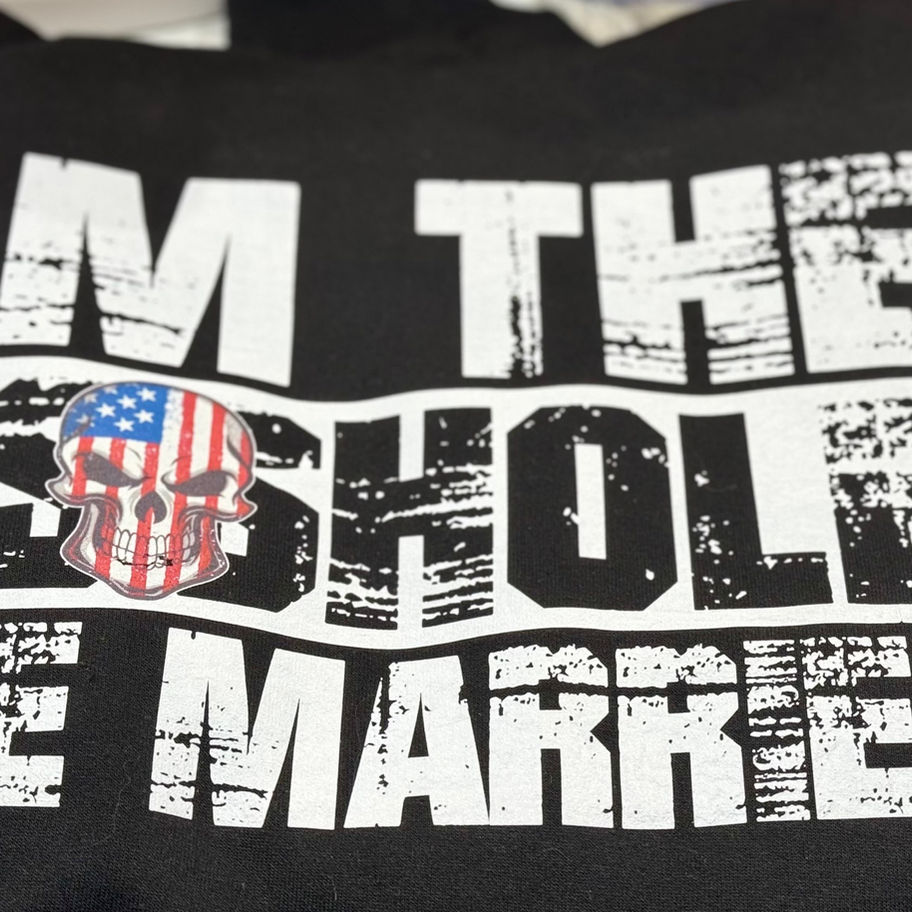 Shirt with text: I am the asshole, the market. Skull with American flag design.