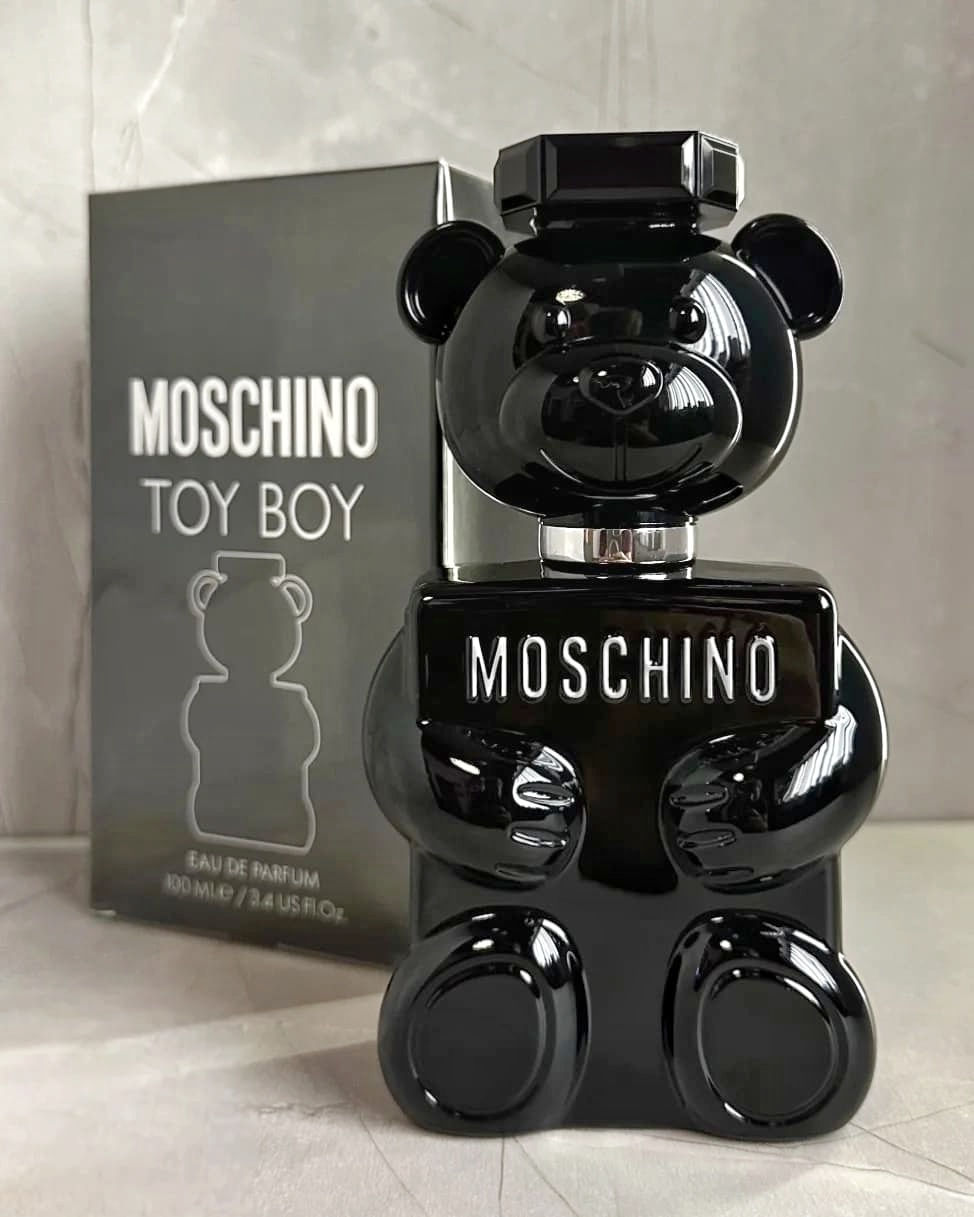 Vista frontal frasco de perfume Moschino Toy Boy en forma de oso negro, junto a su caja de 100 ml