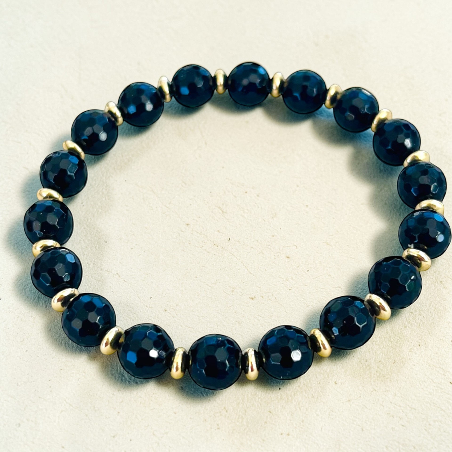 Onyx gemstone bracelet with black faceted beads and gold accents
