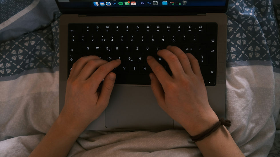 Woman works on laptop in bed