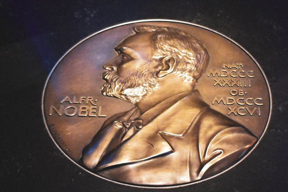 Bronze Nobel Prize medal featuring a profile of Alfred Nobel, text includes "ALFR. NOBEL" and Roman numerals, set against a dark background.