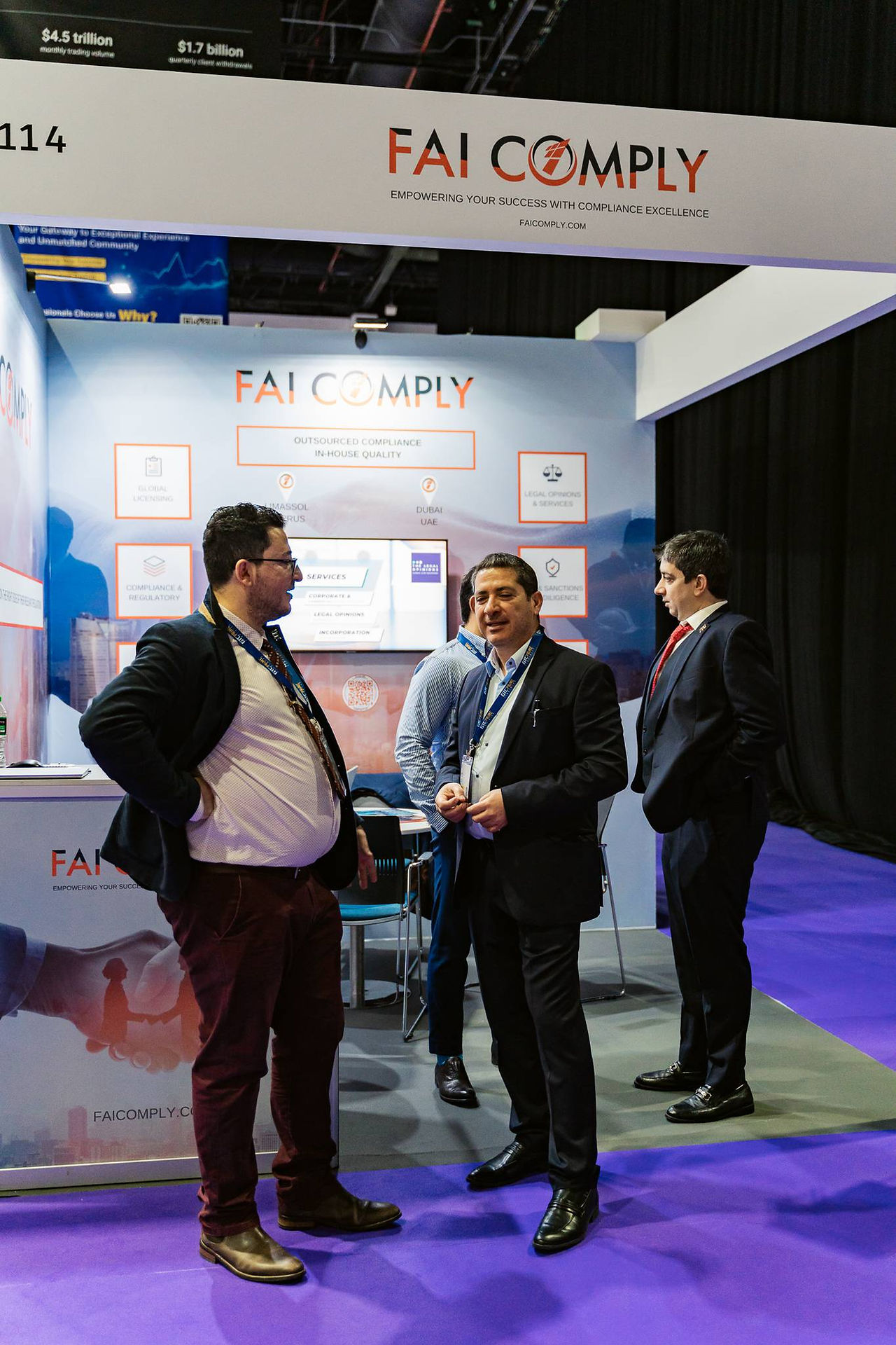 Savvas Patsalides and Constantinos Constantinides talking to associates in the FAI Comply exhibitor booth at the iFX EXPO Dubai 2024.