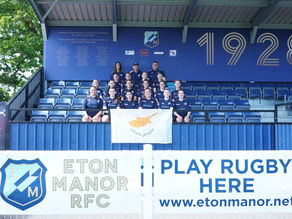 Cyprus Women's Rugby players posing in the stands with the Cyprus flag