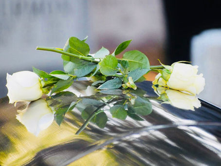Two white roses draped upon a veteran's casket