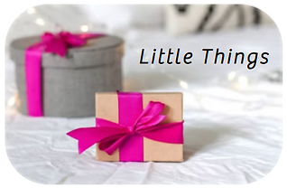 Little Things text. On a tabletop, two small gifts boxes tied with fucshia ribbons.