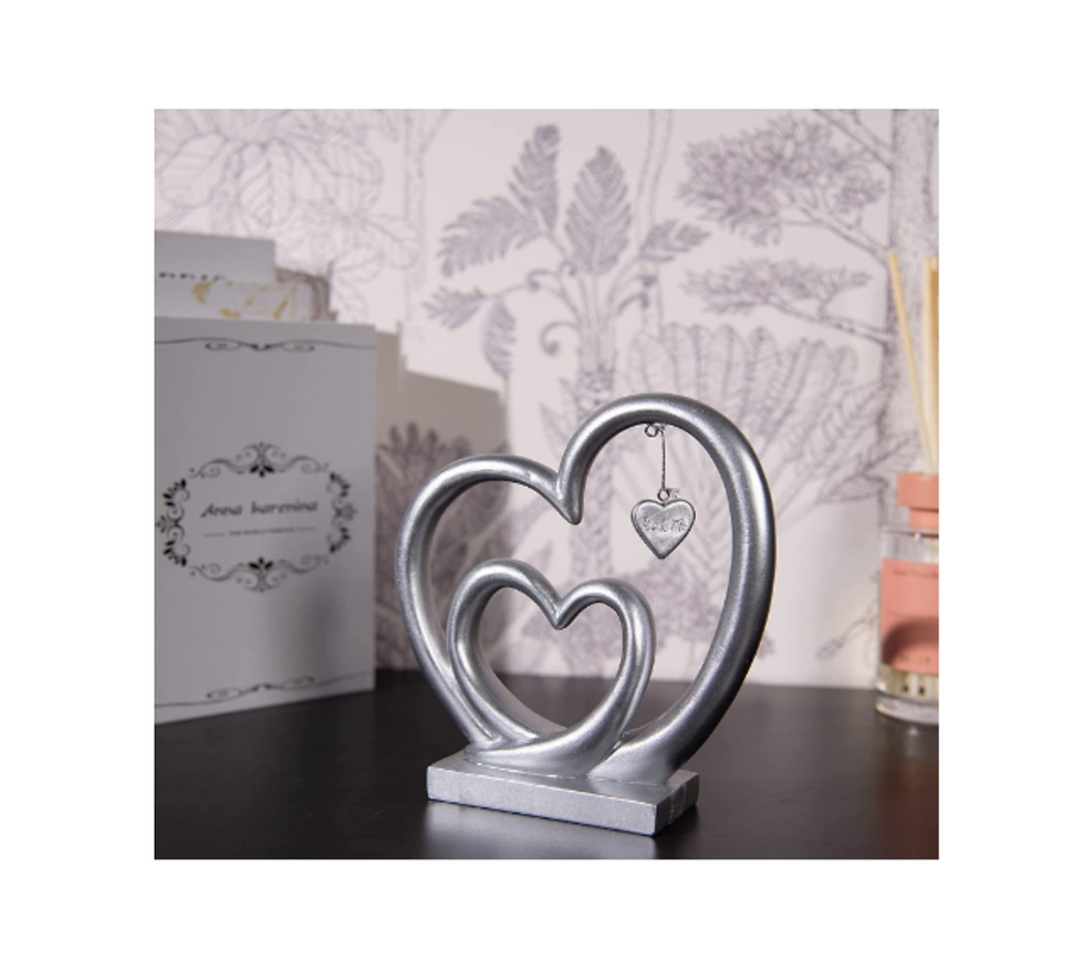 Thumbnail: Silver Resin Three Heart Design Couple Gift sitting on a brown table.