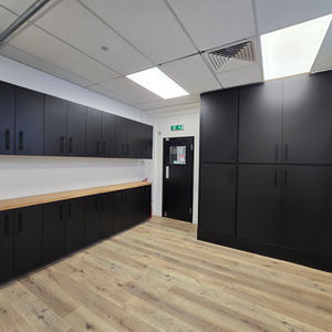 Completed kitchen and storage wall with full‑height black cabinets and modern finishes in an Old Street office. 
