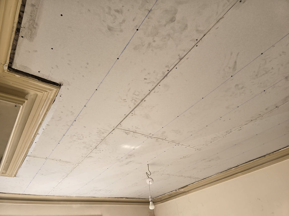 Ceiling with newly installed drywall panels, visible screws and joints before plastering.