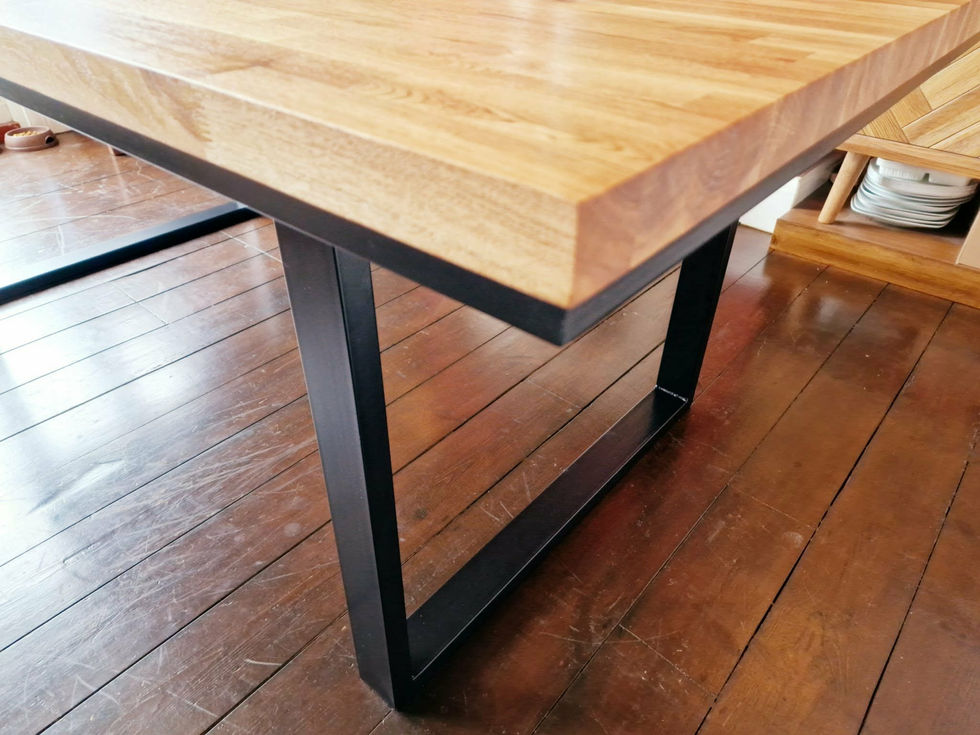 Close‑up of custom dining table with solid timber top and black steel frame.