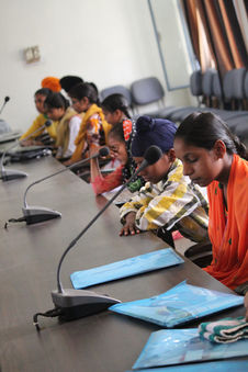 Children sitting in a conference room, attentively participating in a learning session.