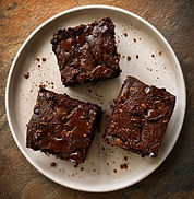 Fudgy vegan chocolate brownies topped with chocolate chips and cut into squares