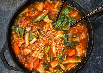 Vegan tteokbokki with ramen, rice cakes, bok choy, cabbage, carrots, and green onions