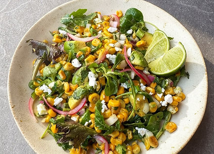 Mexican corn salad with mixed greens, avocado, jalapeño, cilantro, and vegan feta