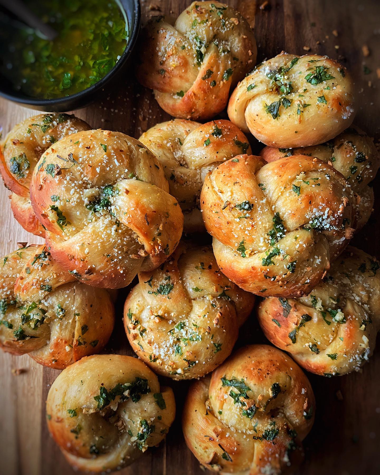 Golden vegan garlic knots brushed with garlic herb butter and topped with parmesan