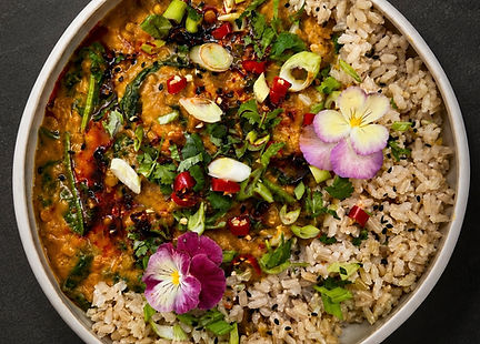 Creamy butternut squash and chickpea curry topped with cilantro, jalapeños, and chili flakes