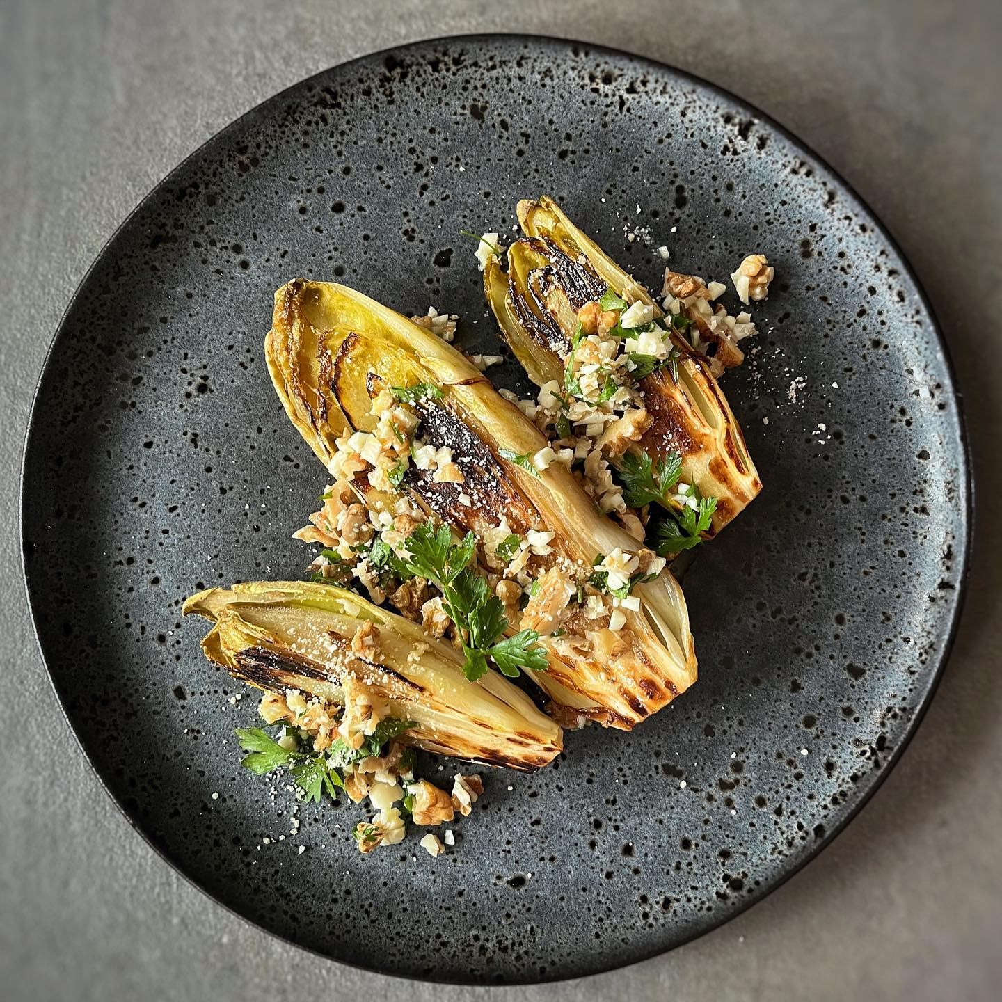 Caramelized seared endives topped with walnut gremolata and vegan parmesan