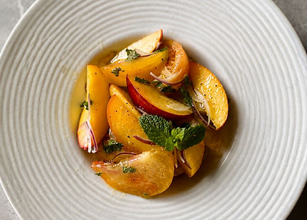 Heirloom tomato, peach, and nectarine salad with red onion, mint, and optional vegan feta