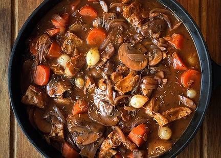 Vegan beef bourguignon with seitan, mushrooms, carrots, pearl onions, thyme, and red wine sauce