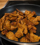 Homemade seitan pieces browned in a skillet with a golden crispy exterior