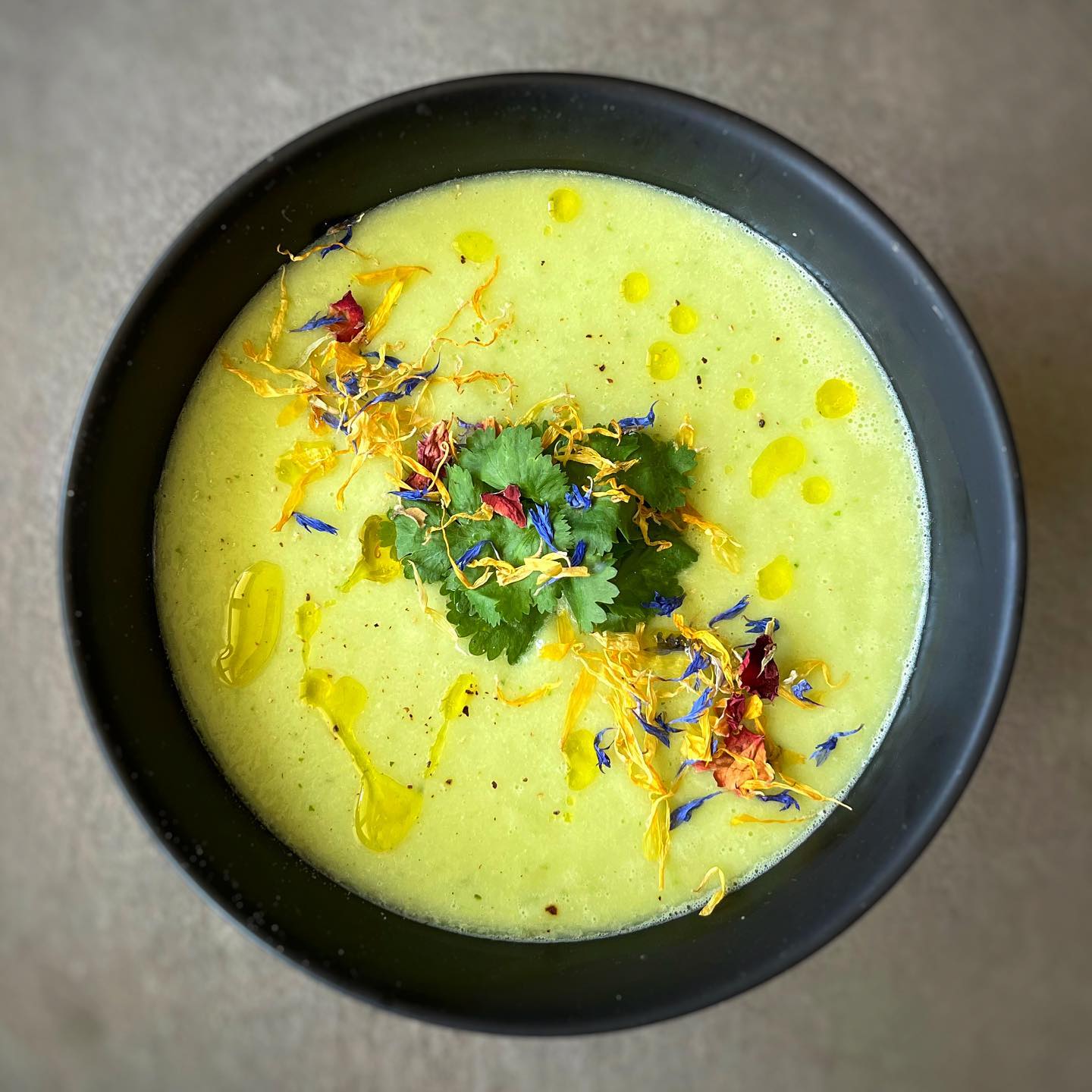 Creamy cucumber avocado gazpacho with fresh herbs and olive oil