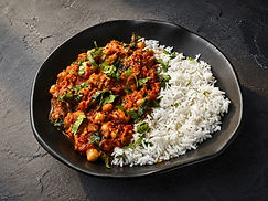 Chana masala with chickpeas, tomatoes, cilantro, sliced jalapeños, and chili flakes served with rice