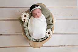 Pasgeboren baby in een zachte omslagdoek tijdens een newborn fotoshoot nabij IJsselstein.