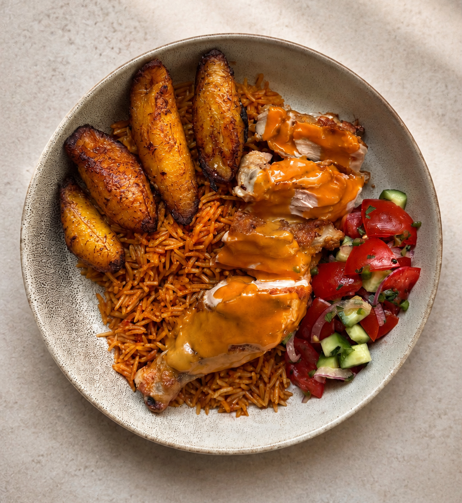 The kuku bowl: a 1/4 piece of sliced chicken, with dodo (fried sweet plantain), kachumbari (tomato and onion salad), and Nigerian jollof rice 