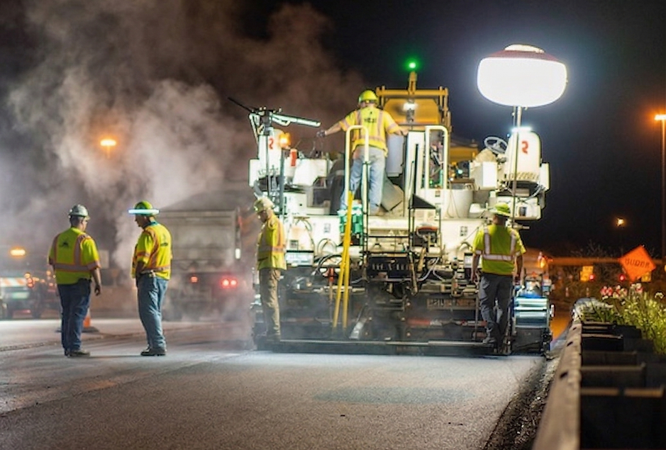 Work zone crew paving road at night