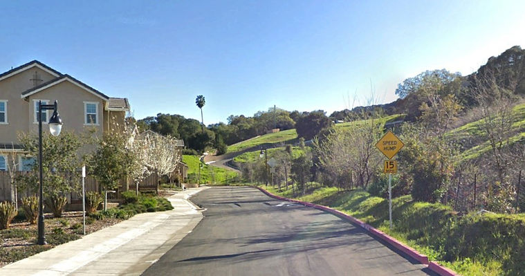 new resiential street showing view of new house and new steep road heading uphill