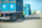 photograph of a lorry driver standing in fountains plants yard securing wooden seedling crates onto a flatbed trailer for delivery